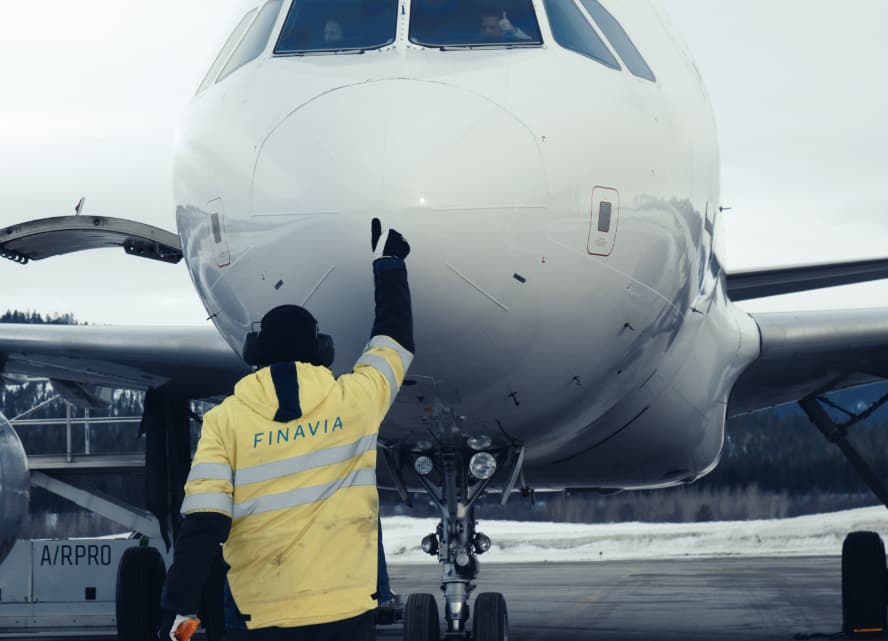 Man marshaling an airplane on Finavia-operated Ivalo airport